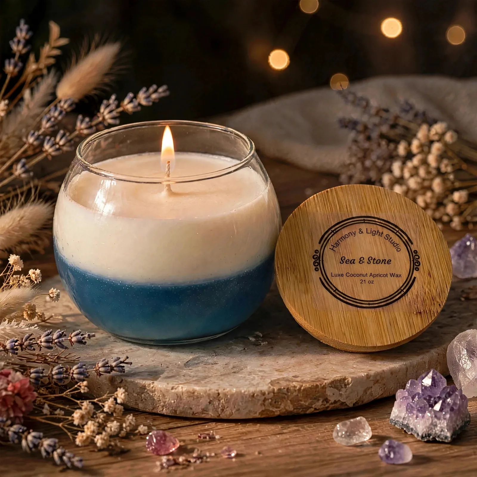 Sea & Stone Scented Candle: Coconut Apricot Wax Blend — lit with a warm flame