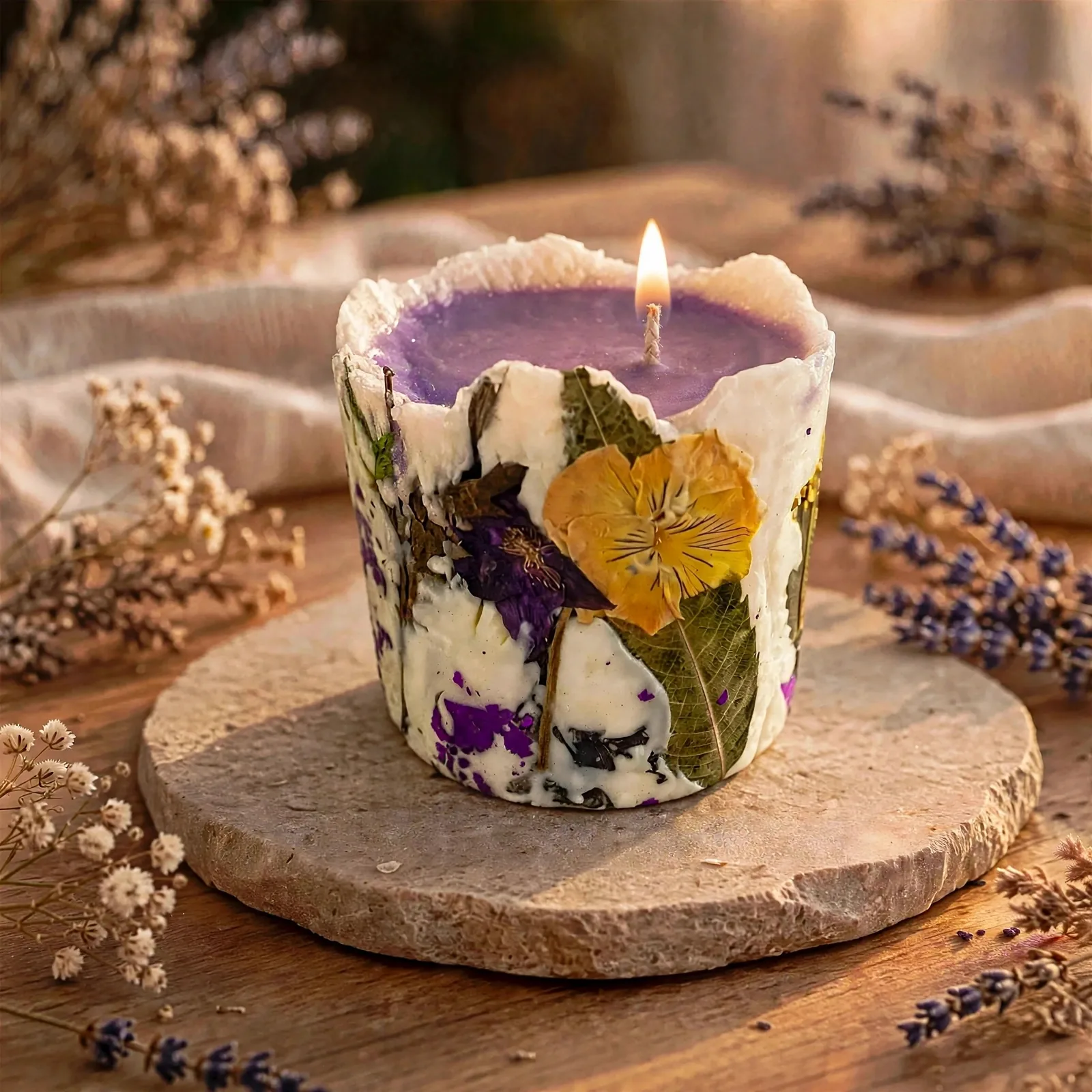 Honeysuckle Pressed Flower Pillar Candle — lit with a warm flame